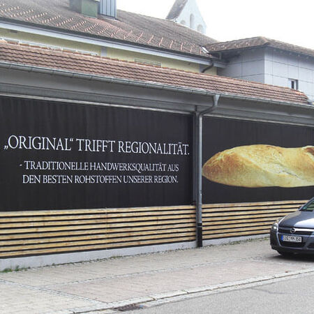 Bannerwerbung für eine Bäckerei an deren Fassade. Produziert von Ruprecht Werbeland aus Krauchenwies.